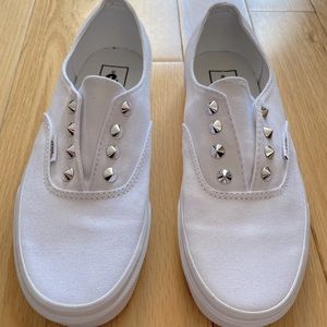 White canvas vans slip on with silver studs.